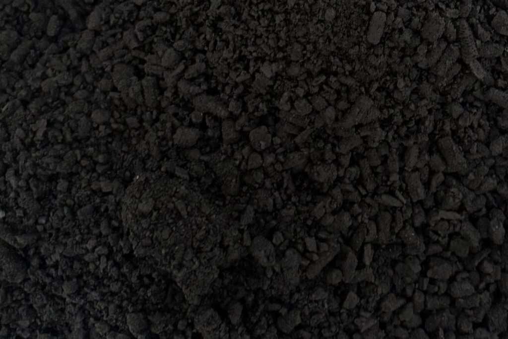 Industrial facility beside farmland, where biochar can enter construction supply chains