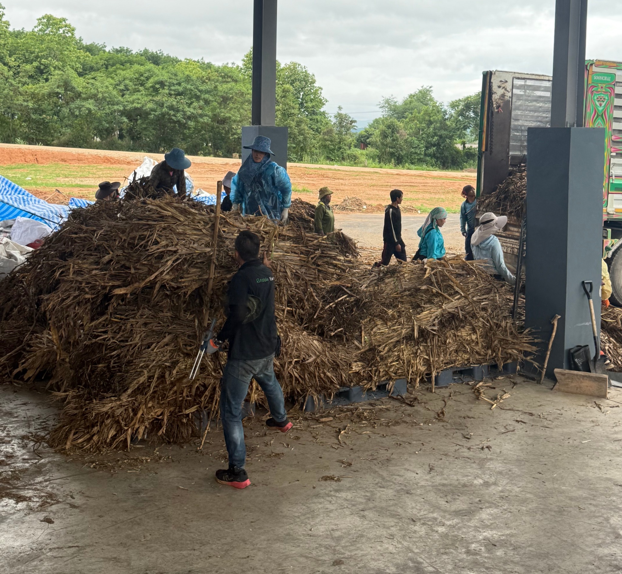 Workers handling corn-stover biomass feedstock at Enable Earth's facility